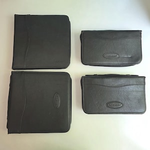 May include: Four black Case Logic storage cases with a textured finish. Two cases are square-shaped and two are rectangular. Each case features a debossed Case Logic logo on the front surface, a zippered closure, and a structured, slim profile.