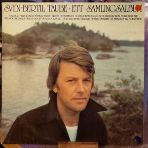 May include: Vintage vinyl record album cover featuring a portrait of Sven-Bertil Taube. The album title is "Ett Samlingsalbum." The cover art showcases Taube in a dark jacket against a scenic backdrop of water and trees. The album's title and track list are printed at the top.