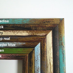 May include: Close-up of a multi-colored wooden picture frame with the words "paradise", "black", "ivory", "deep real", "powder blue", "green", and "pink" written in white text.