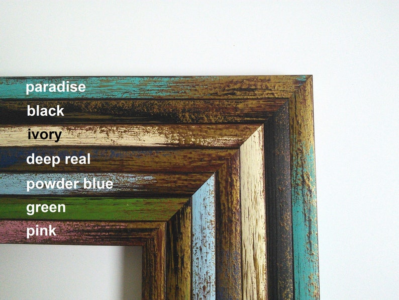 May include: Close-up of a multi-colored wooden picture frame with the words "paradise", "black", "ivory", "deep real", "powder blue", "green", and "pink" written in white text.
