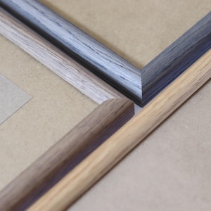 May include: Three picture frames with different wood finishes. The frames are made of wood and have a simple design. The frames are arranged in a way that shows the different finishes.