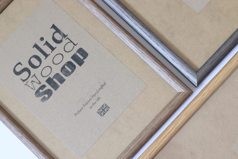 Puede incluir: Tres marcos de fotos hechos de madera maciza. Los marcos son de diferentes colores y estilos. Los marcos est&aacute;n etiquetados como "Solid Wood Shop" y "Marcos de fotos hechos a mano en el Reino Unido".