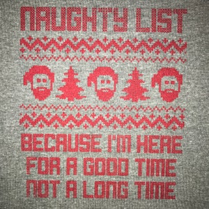 May include: A gray t-shirt with a red pixelated design. The design features a Christmas-themed pattern with the text "NAUGHTY LIST" at the top and "BECAUSE I'M HERE FOR A GOOD TIME NOT A LONG TIME" at the bottom.