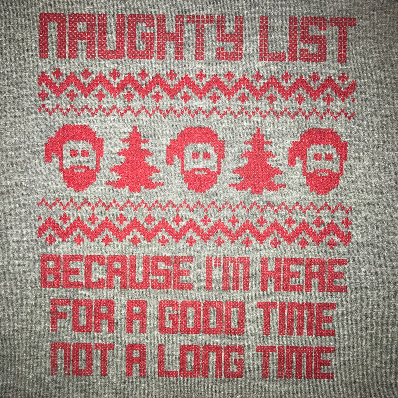 May include: A gray t-shirt with a red pixelated design. The design features a Christmas-themed pattern with the text "NAUGHTY LIST" at the top and "BECAUSE I'M HERE FOR A GOOD TIME NOT A LONG TIME" at the bottom.