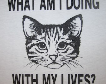 May include: Black and white illustration of a cat with the text "What am I doing with my lives?"