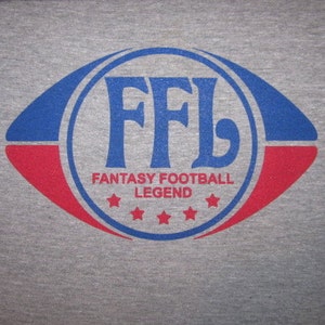 May include: A gray t-shirt with a blue and red football logo that says "FFL Fantasy Football Legend" with five stars.