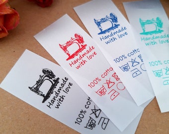 May include: Four white satin labels with black sewing machine illustrations and the text "Handmade with love". Each label has different colored text and washing instructions. The instructions include a 30 degree Celsius wash, do not bleach, do not tumble dry, iron at low temperature, and do not dry clean.