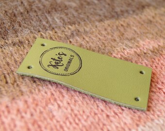 May include: A green leather tag with a circle logo that says "Kate's Originals" in black lettering.