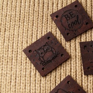 May include: Four brown cork patches with different designs. One patch has an owl, one has the text "BE COOL", and two are blank.