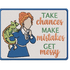 May include: Embroidered patch with a cartoon woman with red hair and a green lizard on her shoulder. The text on the patch reads "Take chances make mistakes get messy".