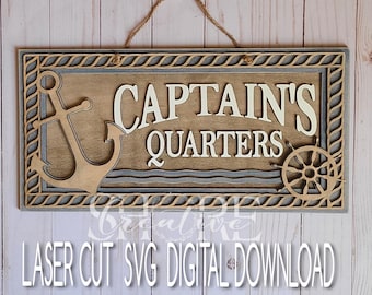 Może przedstawiać: Drewniany znak z linowym uchwytem, w stylu marynistycznym. Znak zawiera napis "Captain's Quarters" białymi literami, a także brązową kotwicę i drewniane koło sterowe.