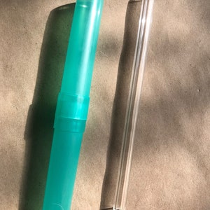 May include: A turquoise blue reusable straw case and a clear glass reusable straw.