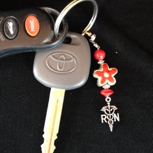 1 RN Beaded Charm. Proud to be a nurse. Hang on your purse, Ikeychain, backpack and more.