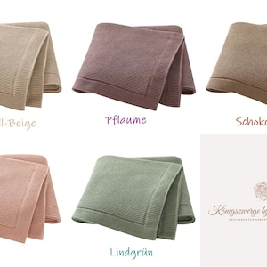 May include: Five folded knit blankets in caramel-beige, plum, chocolate brown, dusty rose, and lime green. Each blanket features a textured knit pattern with a wide, smooth border. The logo for Konigszwerge by Nadine Rosch is visible.