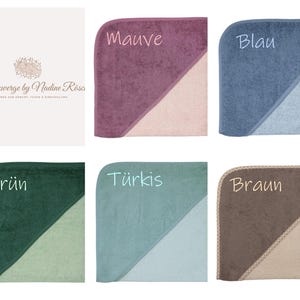 May include: A selection of hooded baby towels in various colors, including mauve, blue, green, turquoise, and brown. Each towel features a contrasting light-colored section and is labeled with its color name. The towels are from the brand "K&ouml;nigszwerge by Nadine R&ouml;so."