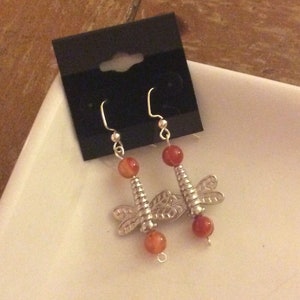 Dragonfly accent, bright orange glass beads surrounding dragonfly, hanging earring