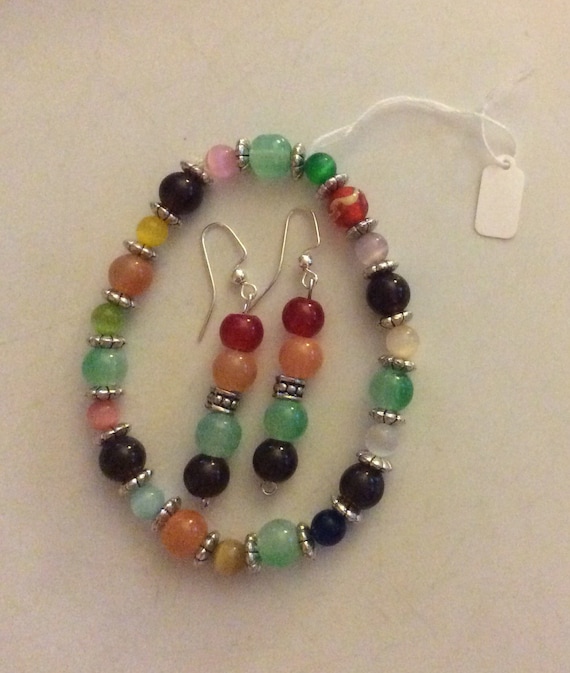 Colorful glass bead bracelet and earring set. Matching colorful orange, red, green and brown glass beads accent this fun pop of color!