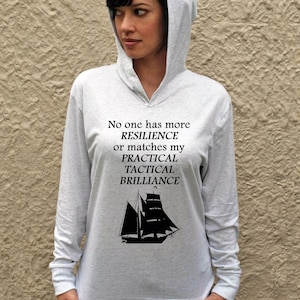 Puede incluir: Una sudadera gris de manga larga con capucha con un gr&aacute;fico de velero negro y el texto "No one has more RESILIENCE or matches my PRACTICAL TACTICAL BRILLIANCE".