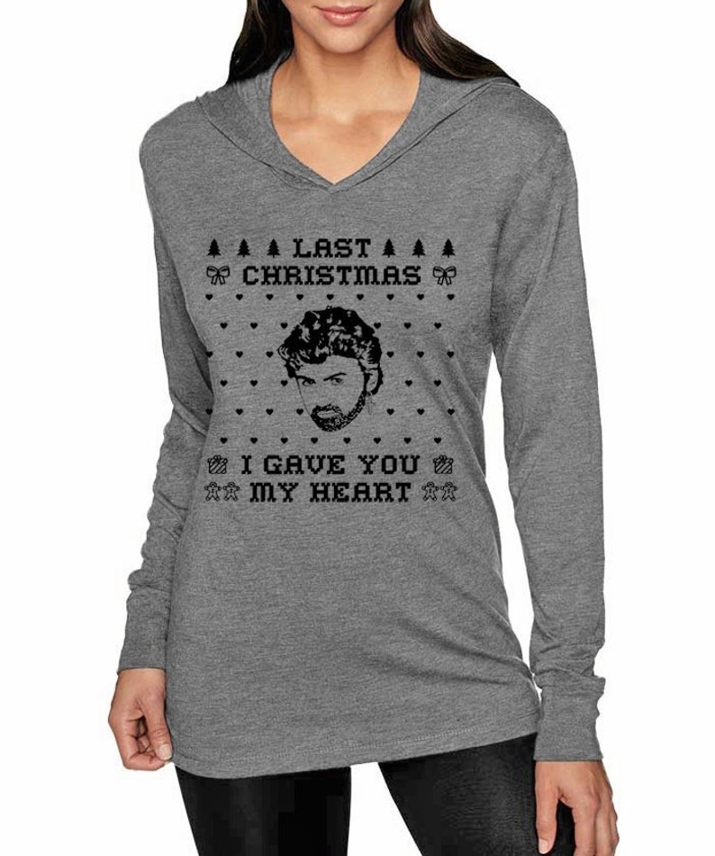 Op de afbeelding: Grijs hoodie met lange mouwen met een zwart-wit kerstthema met een mannengezicht en de tekst "Last Christmas I Gave You My Heart."