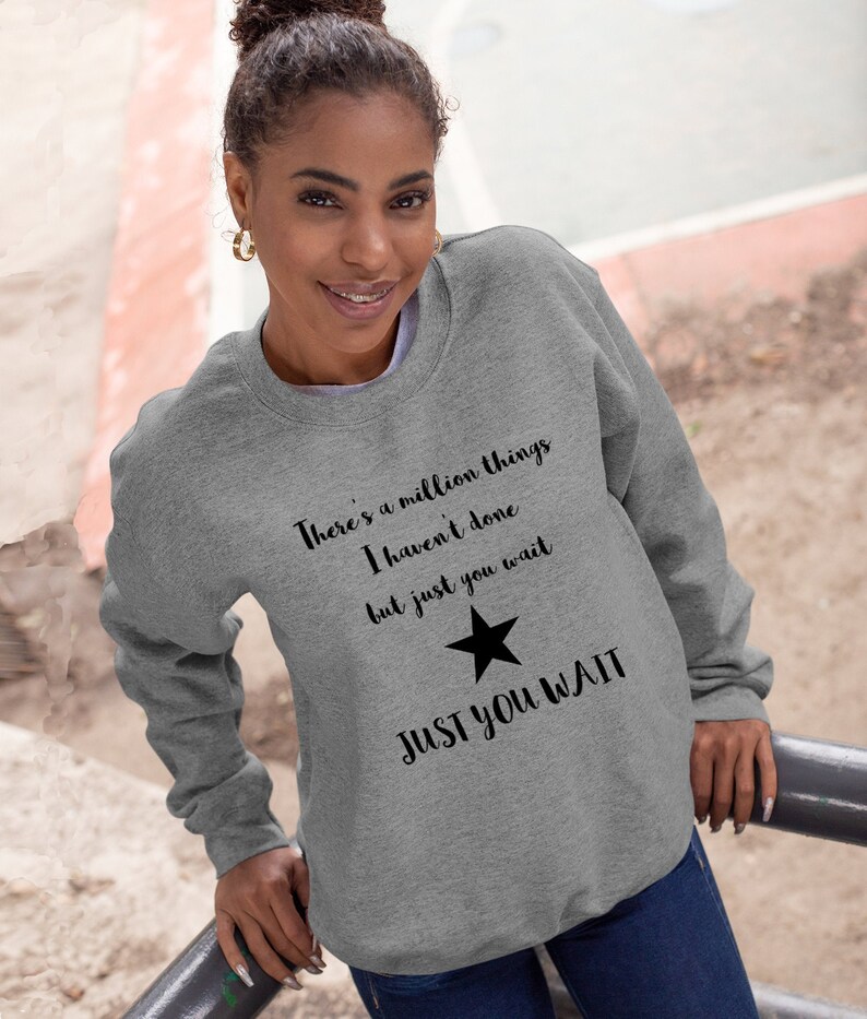 K&ouml;nnte beinhalten: Grauer Pullover mit einem schwarzen Stern und dem Text "There's a million things I haven't done but just you wait JUST YOU WAIT".