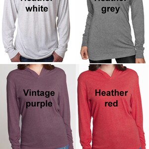 Op de afbeelding: Vier langarmige hoodies in verschillende kleuren: heide wit, heide grijs, vintage paars en heide rood. De hoodies hebben een V-hals en de tekst "Heather white", "Heather grey", "Vintage purple" en "Heather red" staat op de voorkant van elke hoodie gedrukt. De tekst "Vraag naar speciale bestellingen voor andere hoodie kleuren." staat onder de hoodies gedrukt.