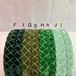 May include: Five velvet headbands in different shades of green. The headbands are all the same style, with a quilted diamond pattern. The headbands are labeled F, f, Gg, Hh, and Jj.
