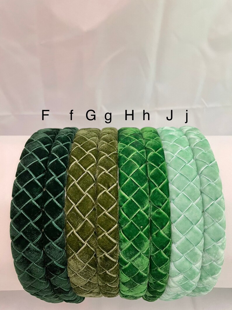 May include: Five velvet headbands in different shades of green. The headbands are all the same style, with a quilted diamond pattern. The headbands are labeled F, f, Gg, Hh, and Jj.