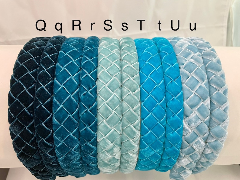 May include: Seven velvet headbands in various shades of blue, from dark blue to light blue. The headbands are all quilted with a diamond pattern. The headbands are labeled with the letters Q, q, R, r, S, s, T, t, U, u.