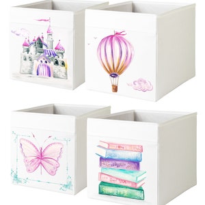 May include: Set of four white fabric storage cubes with colorful designs. The designs include a pink and purple castle, a hot air balloon, a butterfly, and a stack of colorful books.