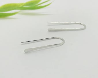 May include: A pair of silver earrings with a simple, curved design. The earrings are made of thin metal and have a hammered texture.