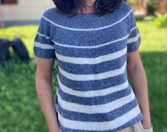 May include: A blue and white striped knit top with short sleeves. The top is made of a soft, textured yarn.
