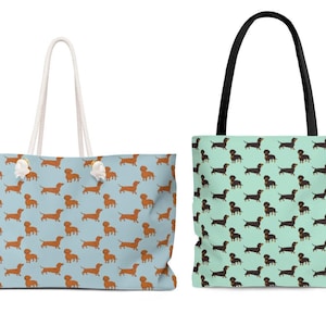 May include: Two tote bags with dachshund patterns. One bag is light blue with brown dachshunds and white rope handles. The other bag is light green with black dachshunds and black handles.