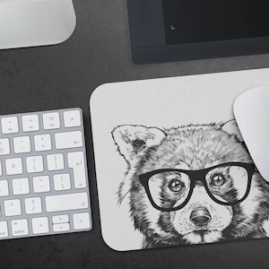 May include: Black and white illustration of a red panda wearing glasses. The red panda is looking directly at the viewer. The background is white.