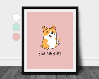 May include: A pink and black framed print with a cartoon illustration of a corgi dog with the text "Stay Pawsitive".
