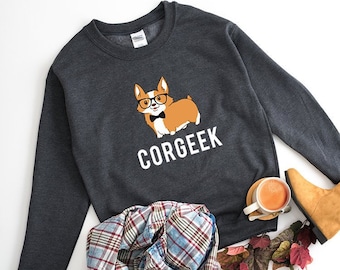 May include: A dark gray sweatshirt with a cartoon corgi wearing glasses and a bow tie. The text "CORGEEKE" is printed in white below the corgi.