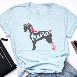 May include: Light blue t-shirt with a floral design featuring a silhouette of a dog with the word "Mama" printed on it.