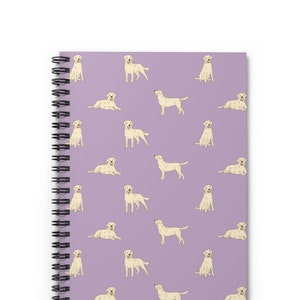 May include: A purple spiral notebook with a repeating pattern of white Labrador Retrievers in various poses.