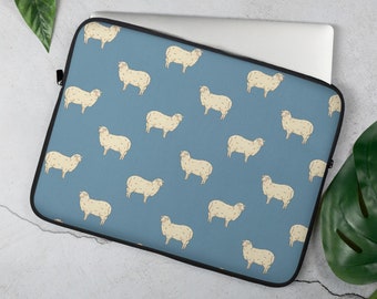 May include: A blue laptop sleeve with a white sheep pattern. The sheep are repeated in a grid pattern on the sleeve.