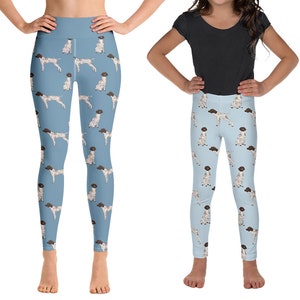 May include: Two pairs of blue yoga leggings with a white and brown dog print. The leggings are shown on two people, one adult and one child.