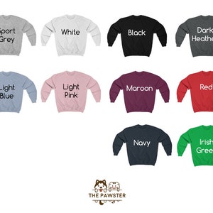 May include: A set of ten crewneck sweatshirts in various colors, including sport grey, white, black, dark heather, light blue, light pink, maroon, red, navy, and Irish green. Each sweatshirt has a different color text label on the front, indicating the color of the sweatshirt.