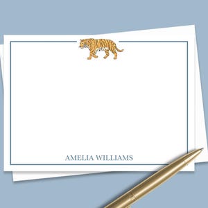 May include: White stationery with a blue border and a tiger illustration at the top. The name "Amelia Williams" is printed at the bottom.