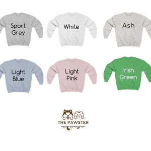 Puede incluir: Seis sudaderas de diferentes colores con el texto "Sport Grey", "White", "Ash", "Light Blue", "Light Pink" e "Irish Green" impreso en ellas. Las sudaderas est&aacute;n todas dispuestas en plano sobre un fondo blanco. El texto "THE PAWSTER" est&aacute; impreso debajo de las sudaderas.