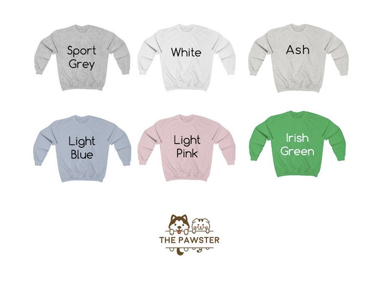 Puede incluir: Seis sudaderas de diferentes colores con el texto "Sport Grey", "White", "Ash", "Light Blue", "Light Pink" e "Irish Green" impreso en ellas. Las sudaderas est&aacute;n todas dispuestas en plano sobre un fondo blanco. El texto "THE PAWSTER" est&aacute; impreso debajo de las sudaderas.