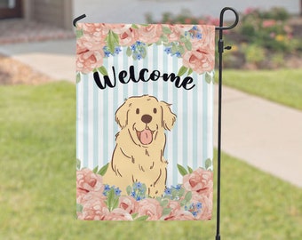 May include: A welcome garden flag with a cute cartoon golden retriever dog sitting in a bed of pink flowers. The flag has a blue and white striped background with the word "Welcome" in black.