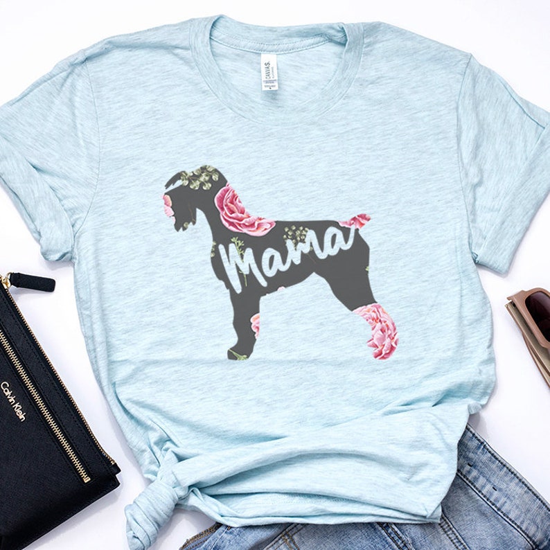 May include: Light blue t-shirt with a floral design featuring a silhouette of a dog with the word "Mama" printed on it.