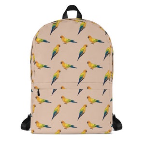 May include: A beige backpack with a repeating pattern of yellow, green, and blue parrots. The backpack has black straps and a zippered pocket.