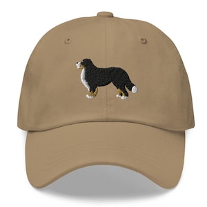 May include: A tan baseball cap with an embroidered Bernese Mountain Dog in black, white, and brown.