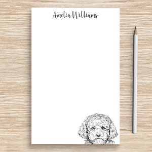 May include: White notepad with the name "Amelia Williams" printed at the top. A black and white illustration of a poodle's head is at the bottom of the notepad.