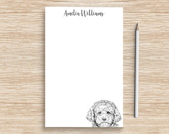 May include: White notepad with the name "Amelia Williams" printed at the top. A black and white illustration of a poodle's head is at the bottom of the notepad.
