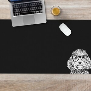 May include: Black desk mat with a white doodle of a dog wearing glasses. The dog is looking directly at the viewer.